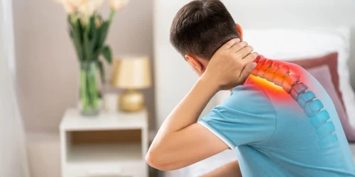 Man holding neck with pain radiating down the spine indicating a bulging disc.