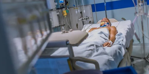 A patient lying on the hospital bed as a result of complication from laminectomy surgery.