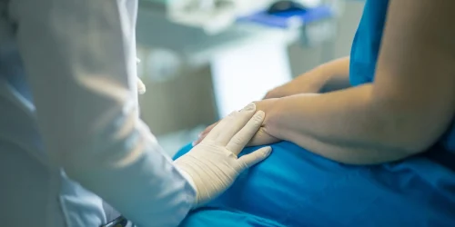 Picture of a pain management doctor assuring patient before the pain management procedure.