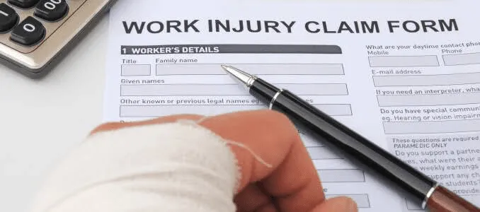 A patient filling out a work injury claim form with his hand injured.