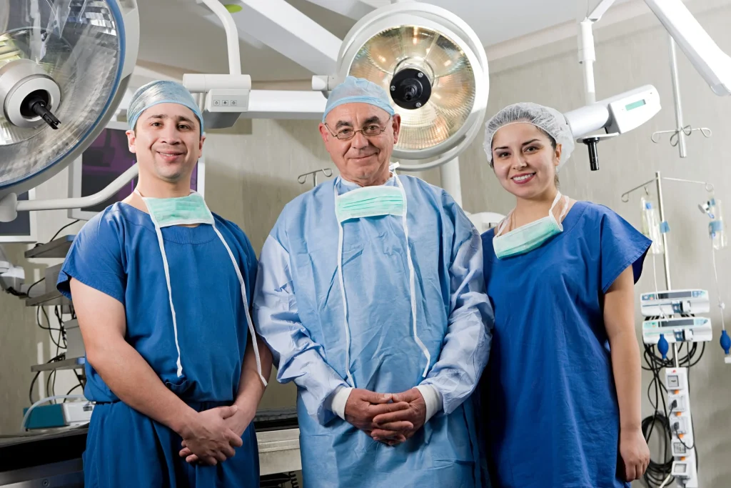 Three endoscopic spine surgeons in an operating room, posing for the camera.