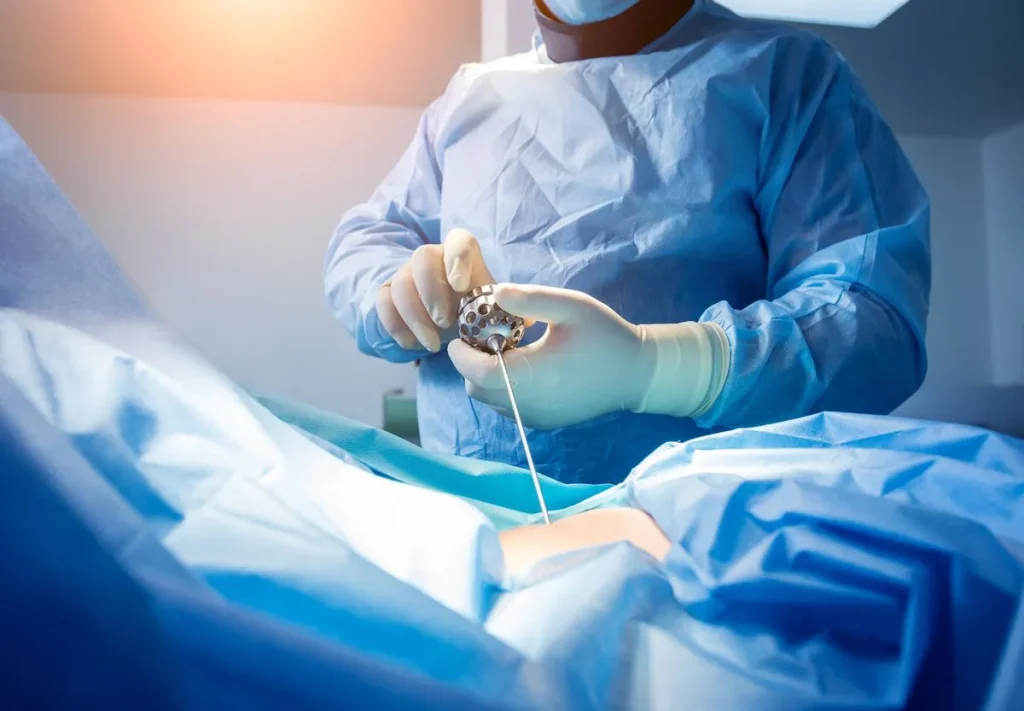A surgeon performs a procedure using medical instruments in an operating room.