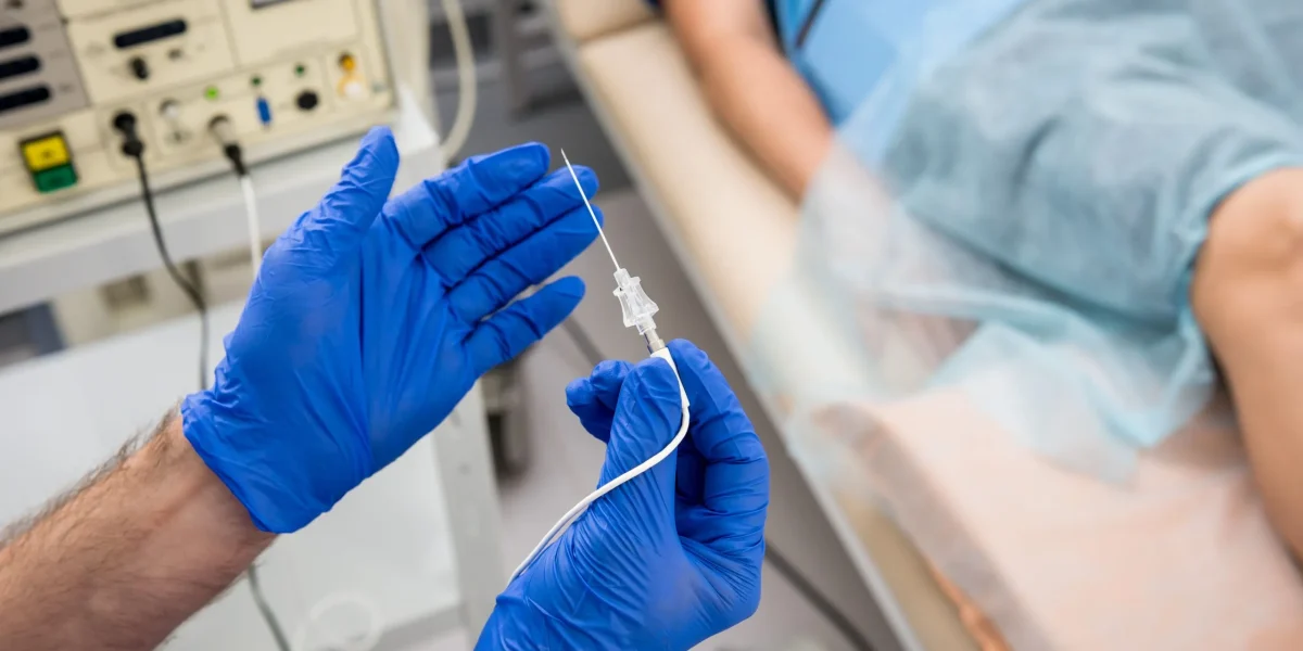 A medical professional in gloves holds a syringe near a patient, related to herniated disc treatment.