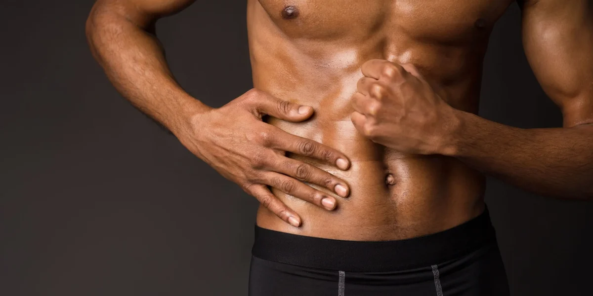 Man clutching his lower back, illustrating pain from L5-S1 herniation, related to symptom management of lower back pain.